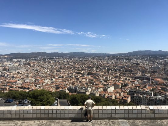 Ein Mann steht vor einer Stadt - Marseille.